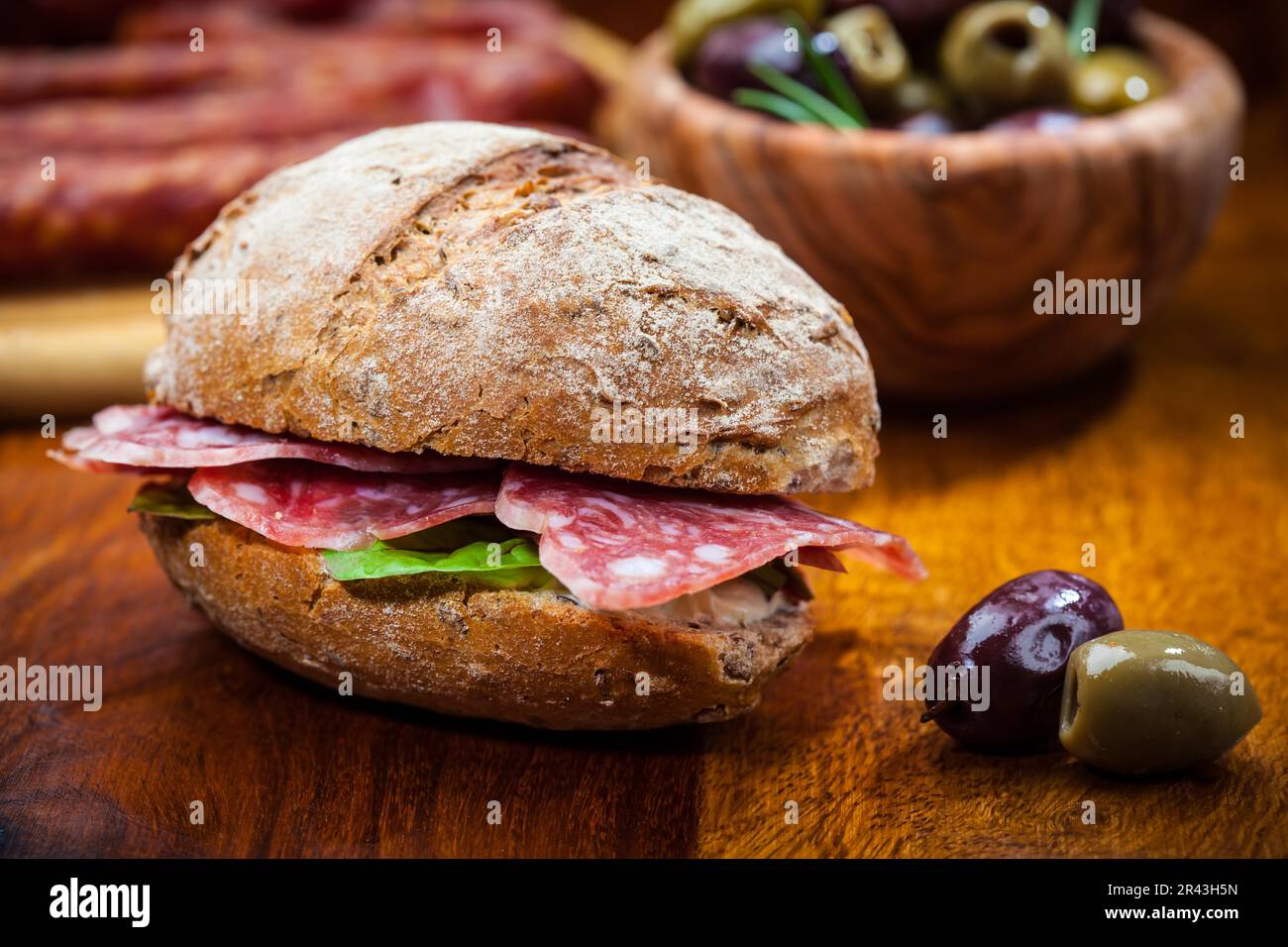Whole grain sandwich with Italian salami, goat cheese and fresh olives