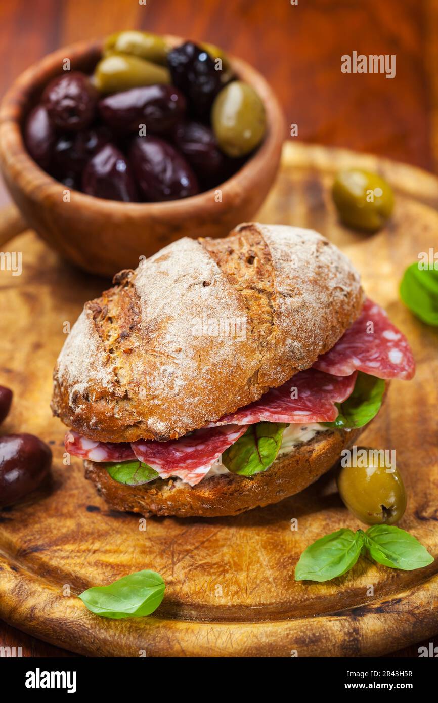Whole grain sandwich with Italian salami, goat cheese and fresh olives