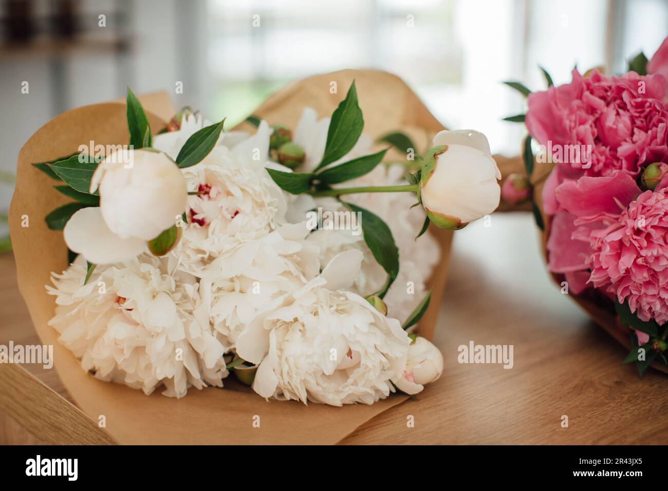 Peonies on a table in a flower shop, close-up. Stock Photo