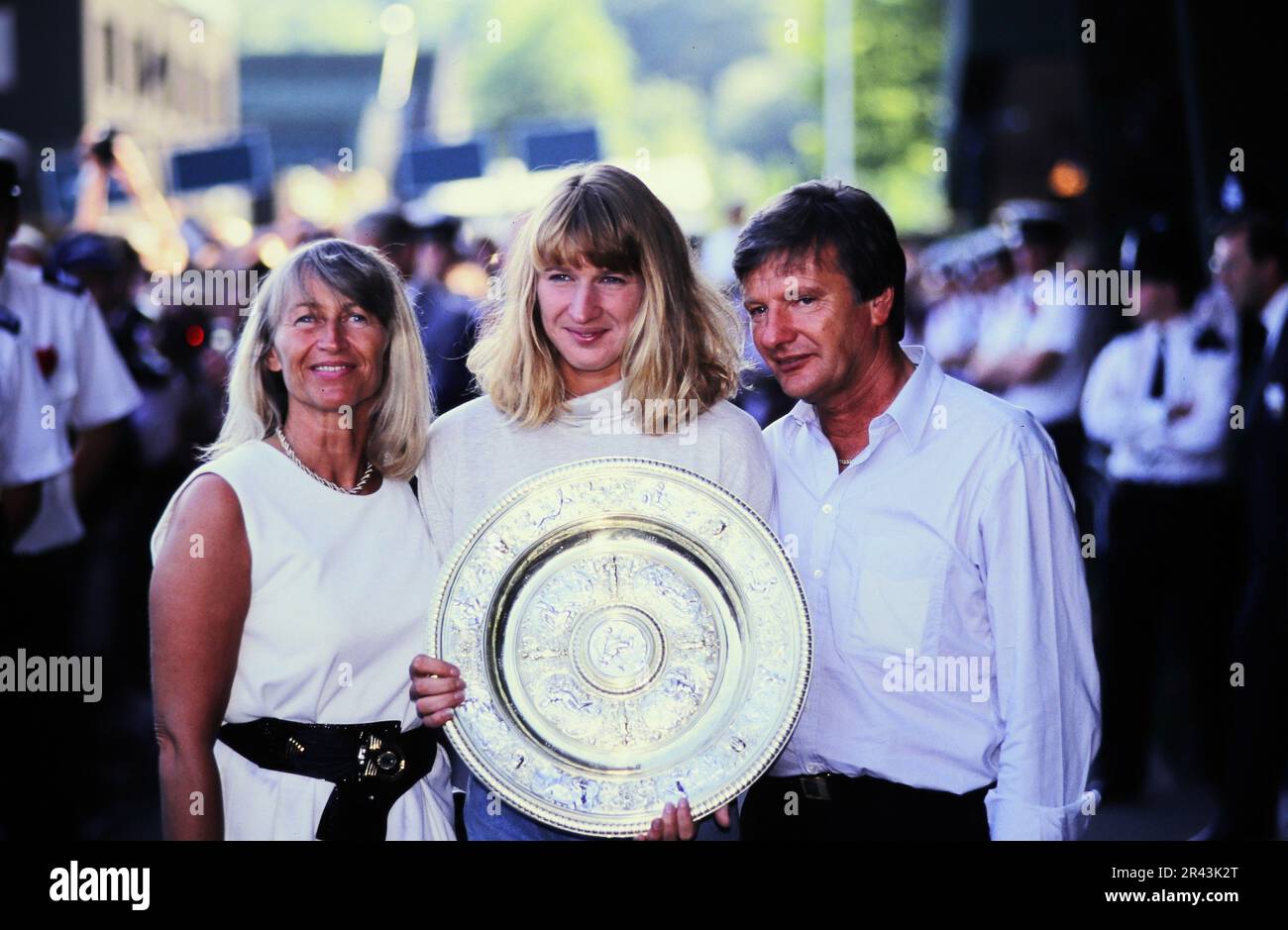 Stefanie Steffi Graf, deutsche Tennisspielerin, präsentiert ihre Trophäe von Wimbeldon 1991 neben den Eltern Vater Peter und Mutter Heidi. Stock Photo