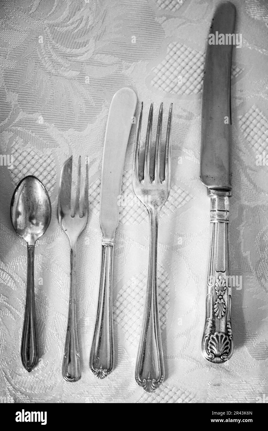 Silvery cutlery laid ready for an English high tea.  May 2019 Stock Photo