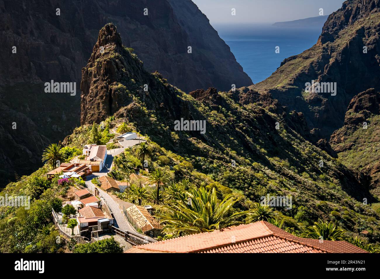Masca Tenerife with no people amidst lush greenery of the Teno mountains, featuring a sunlit alley on a mountain ridge with a great view over the roof Stock Photo