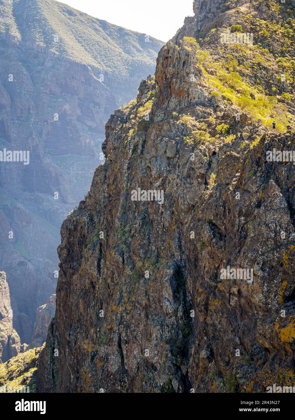 A man seeks a thrilling adventure as he treks the Calzada de los Antiguos path, a daring hiking trail along the edge of a mountain ridge with breathta Stock Photo