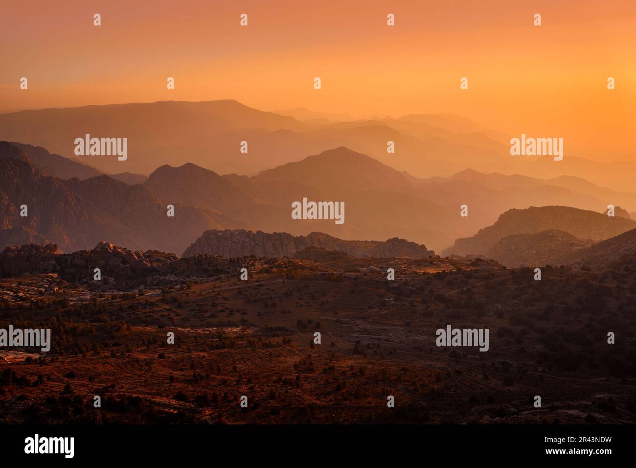 Jordan sunset landscape. Rocky mountain with orange evening in Dana Biosphere Reserve, Jorda. Traveling in Arabia. Stones and valley in Dana nature, w Stock Photo