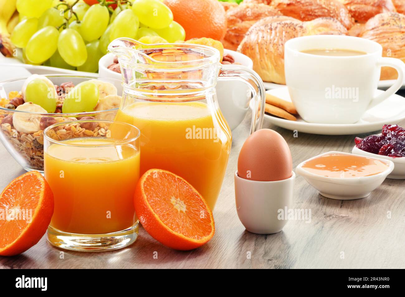 Breakfast including coffee, bread, honey, orange juice, muesli and fruits Stock Photo