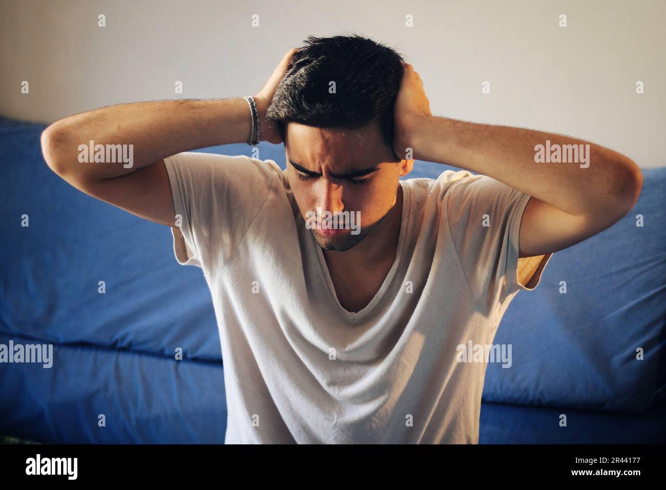 Man dressed in white with a headache. Stock Photo