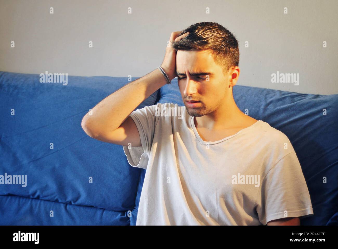 Man dressed in white with a headache. Stock Photo