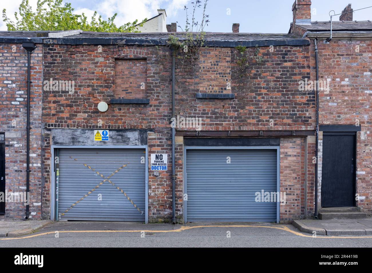 Liverpool, united kingdom May, 16, 2023 sidewalk by street wall & door, back street lock up's, restricted parking Stock Photo