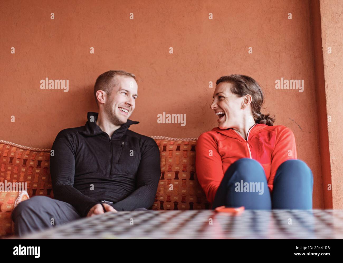 A couple smile at each other while sitting on a couch in Morocco Stock Photo