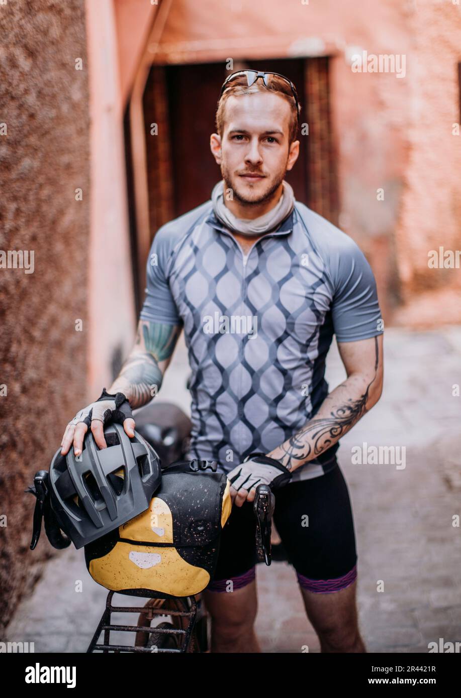 A male cyclist stands for a portrait in a street in Marrakesh, Morocco Stock Photo