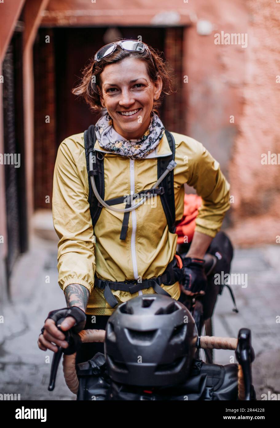 female cyclist stands for a portrait in a street in Marrakesh, Morocco Stock Photo