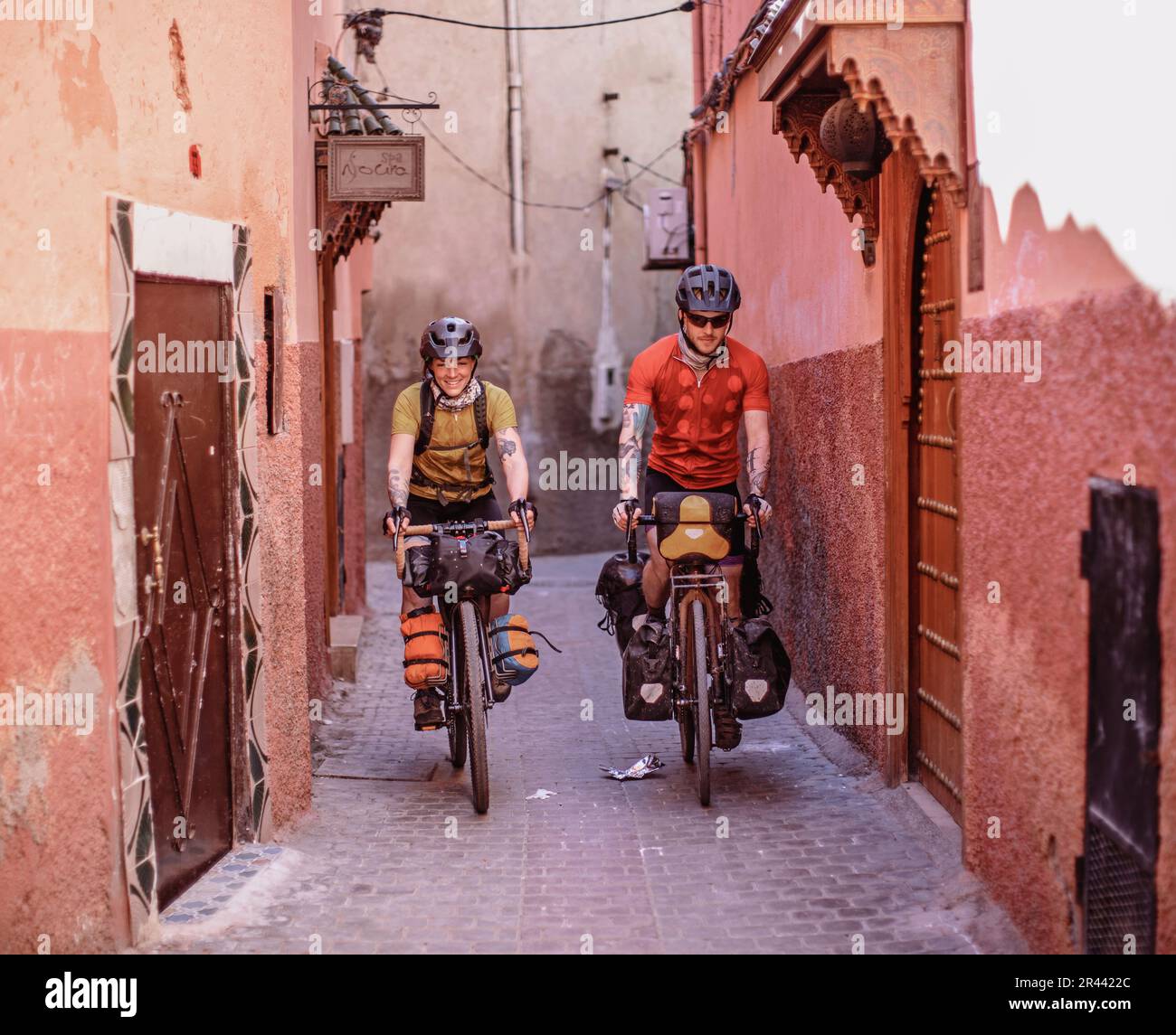 two bikers ride through the narrow streets of the Medina, Marrakesh Stock Photo