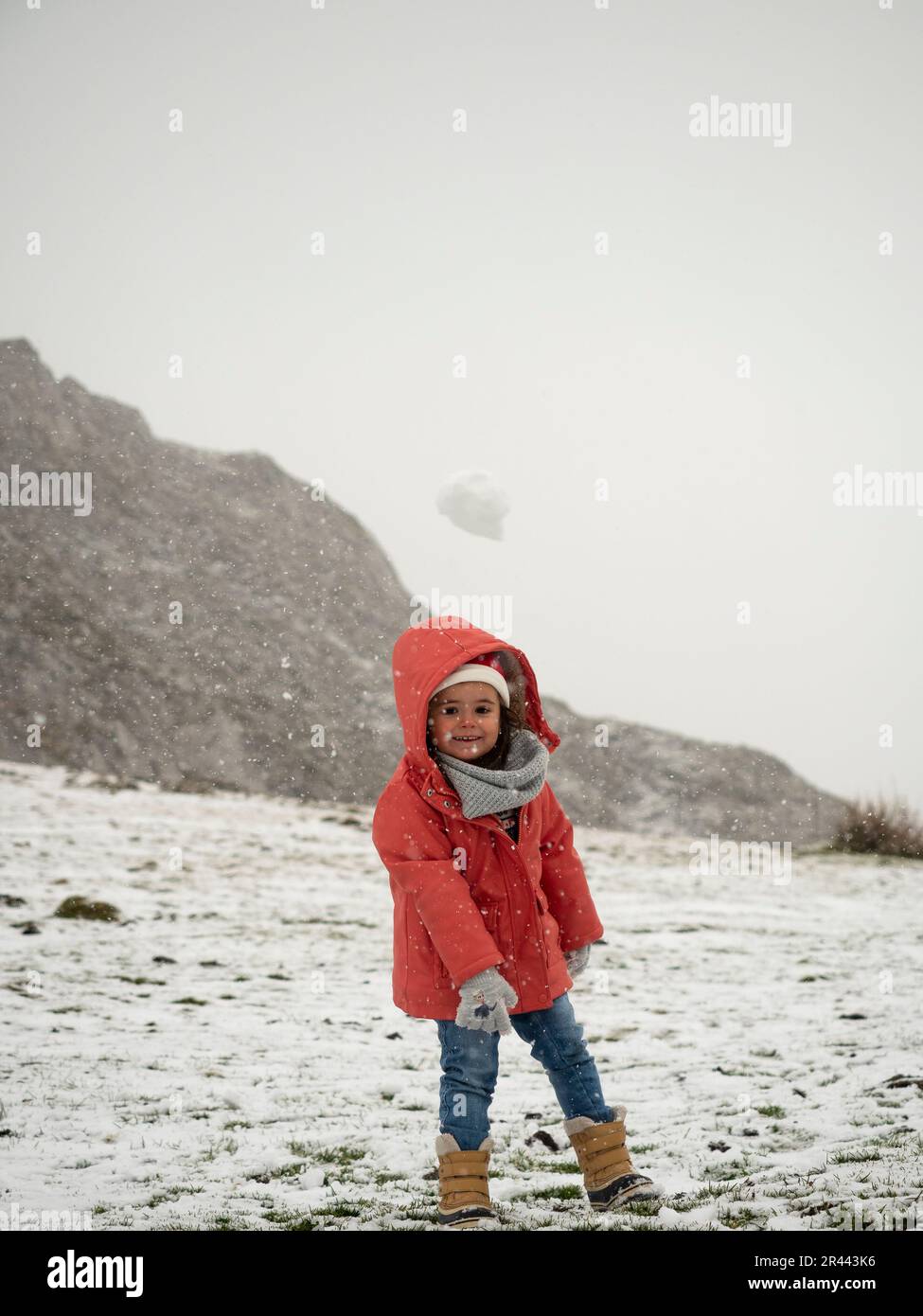 little girl throwing snowball Stock Photo