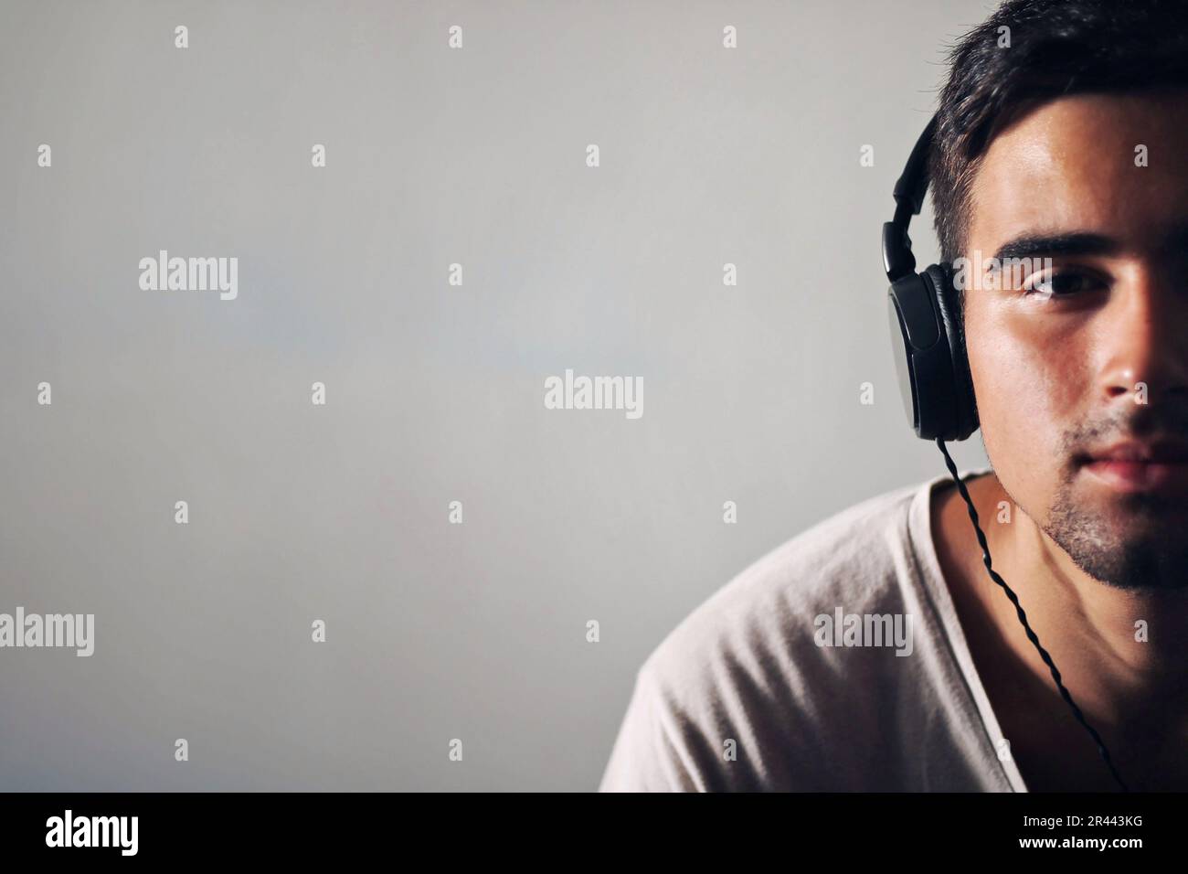 Man dressed in white listening to music. Stock Photo