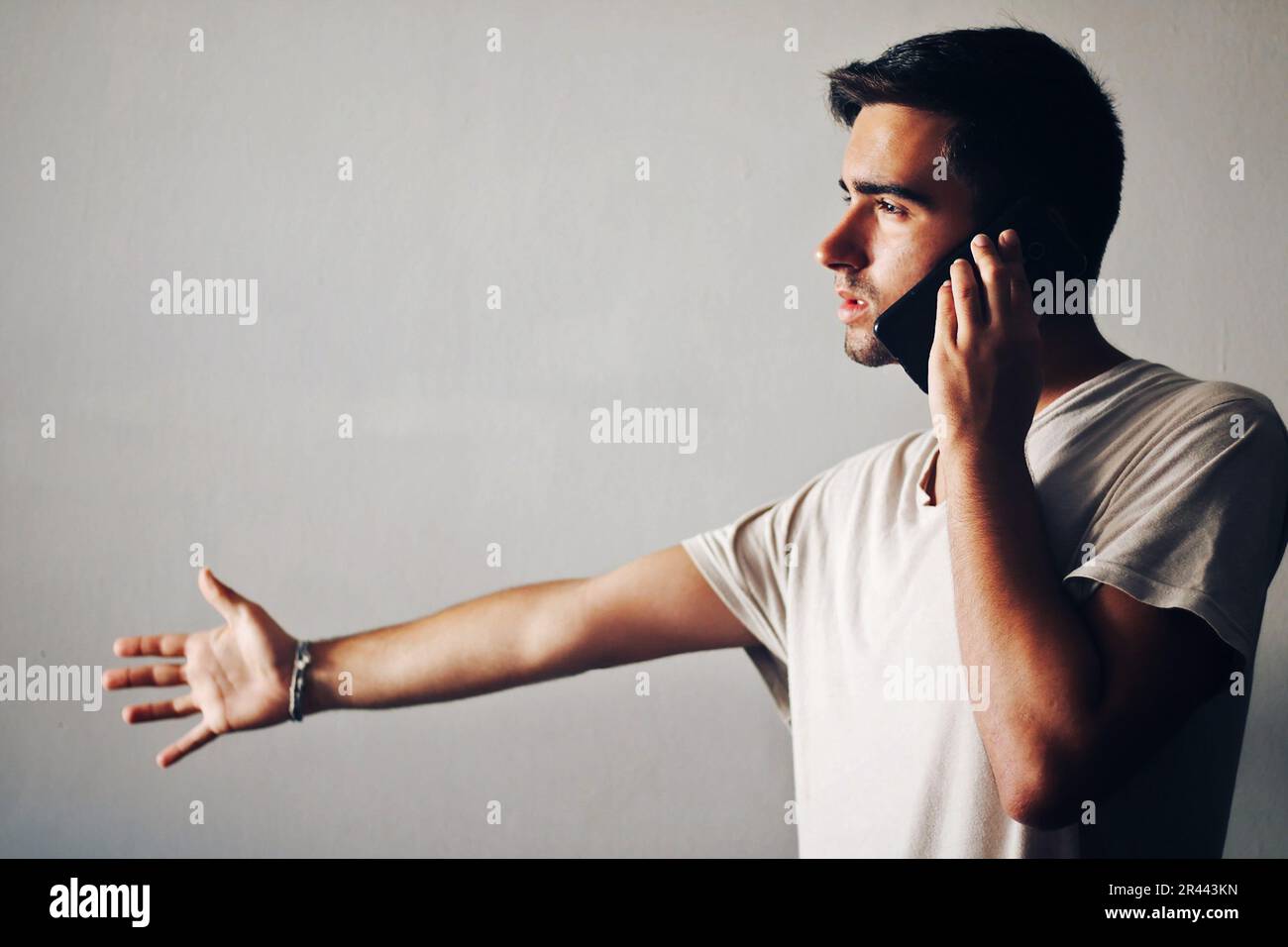 Man dressed in white talking on the phone. Stock Photo