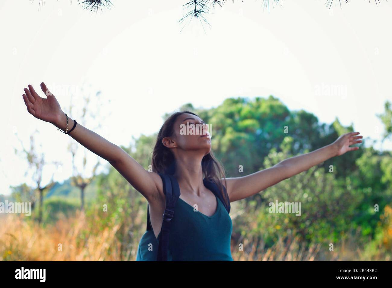 Woman dressed in green raising her arms on the mountain Stock Photo - Alamy