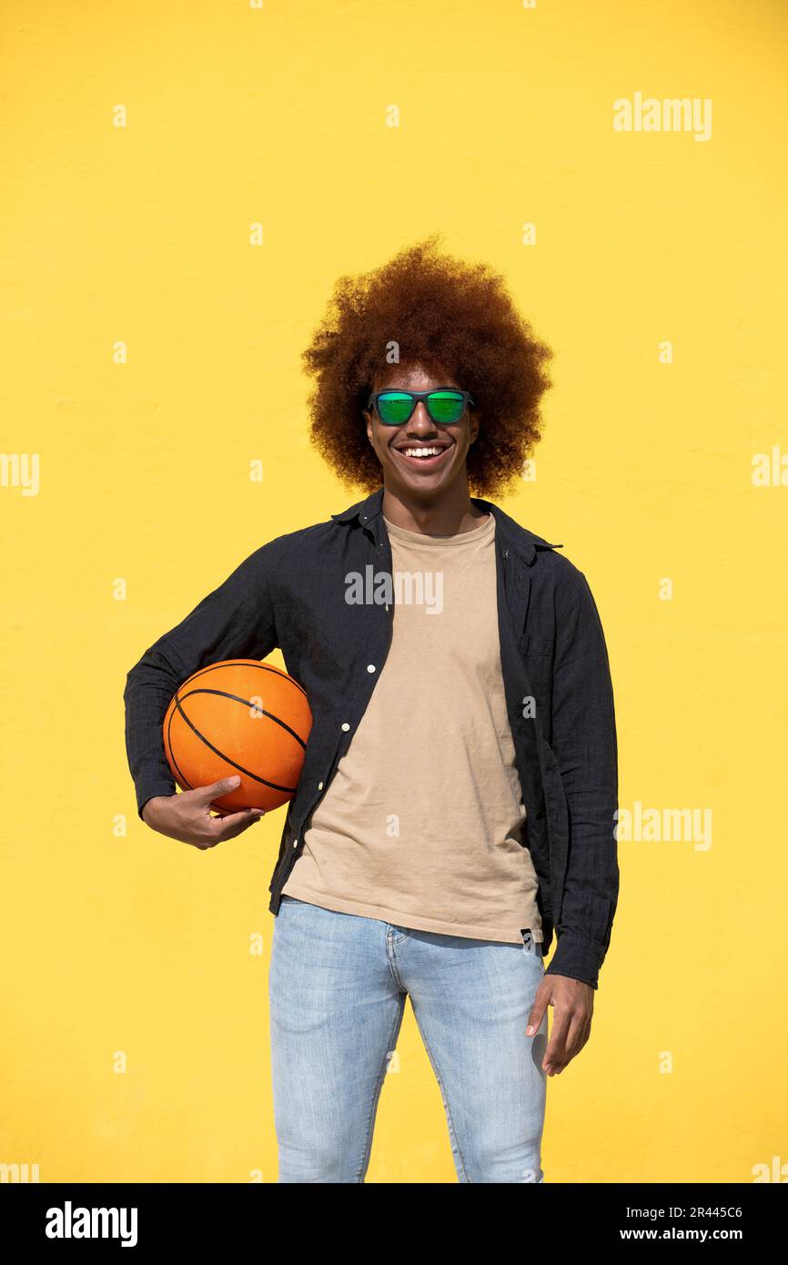 Portrait of a curly hair man holding a basket ball Stock Photo