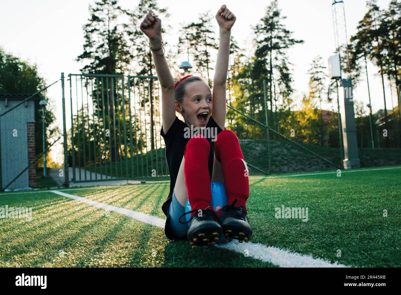 girl cheering for her team mates whilst playing football Stock Photo