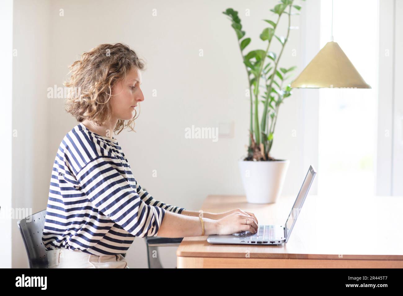 young woman typing in home office with laptop Stock Photo
