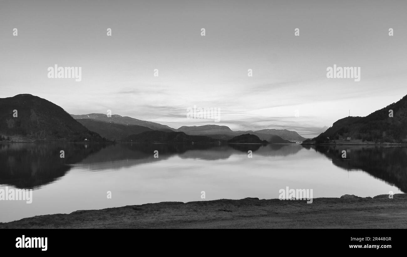 Fjord with view of mountains and fjord landscape in Norway in black and white. Landscape shot with sunny from the north of Scandinavia Stock Photo