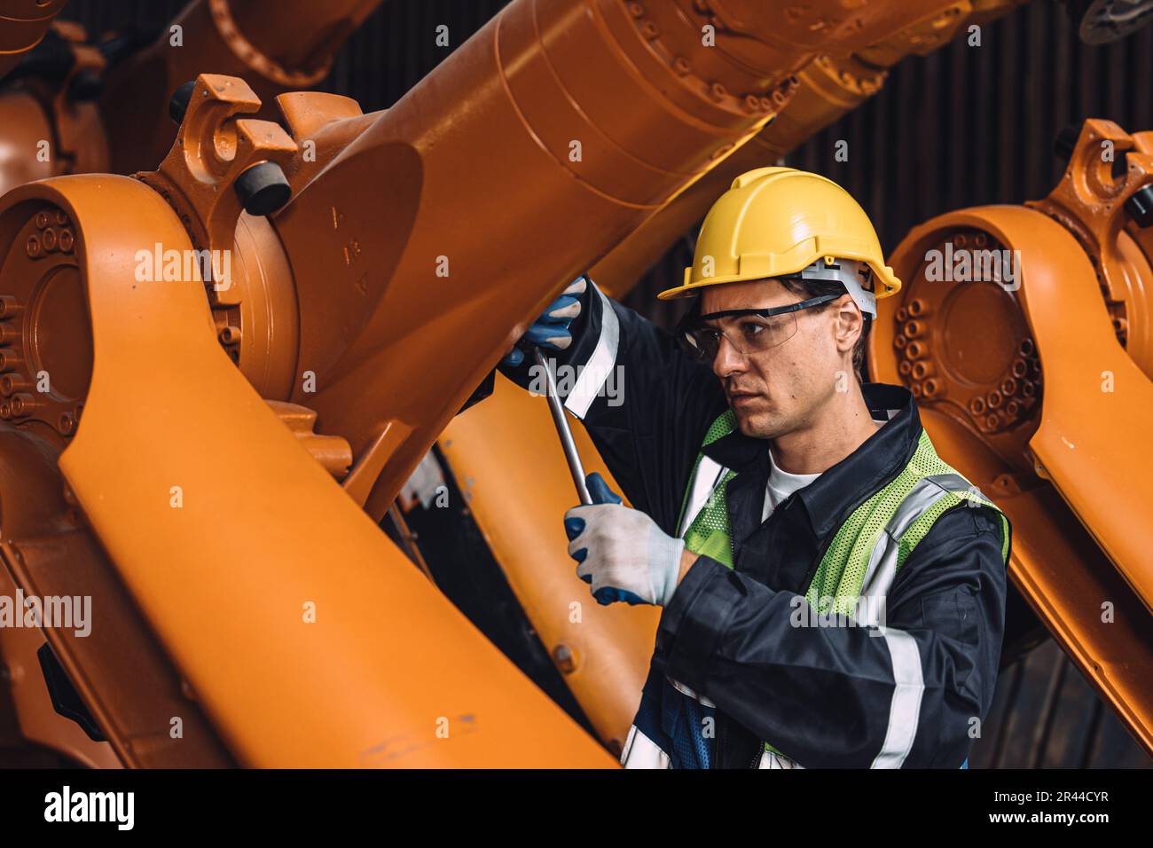 Engineer working service maintenance robot arm welding in assembly line automation factory industry. Stock Photo