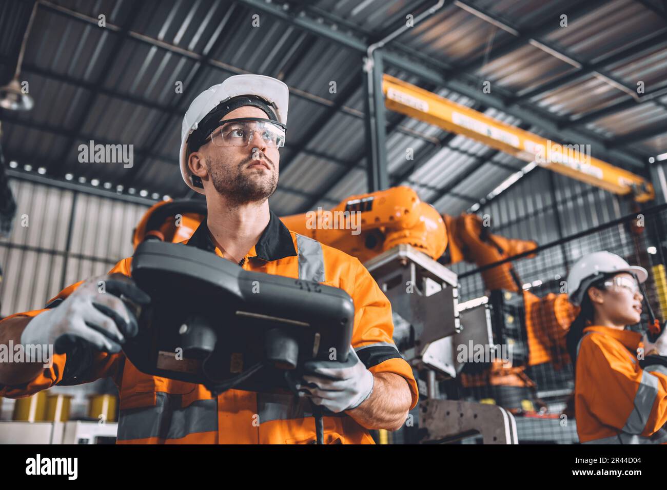 Engineer team working with robot welding in automation factory. People