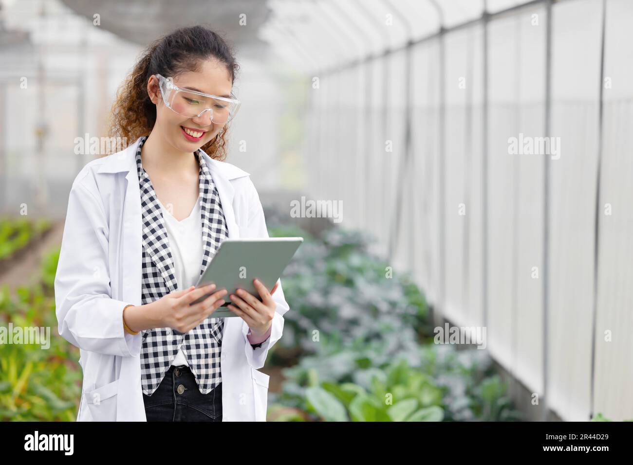 Happy Smiling Scientist Modern Farmer using Tablet Monitor Agriculture Farm Plant Research Working. Stock Photo