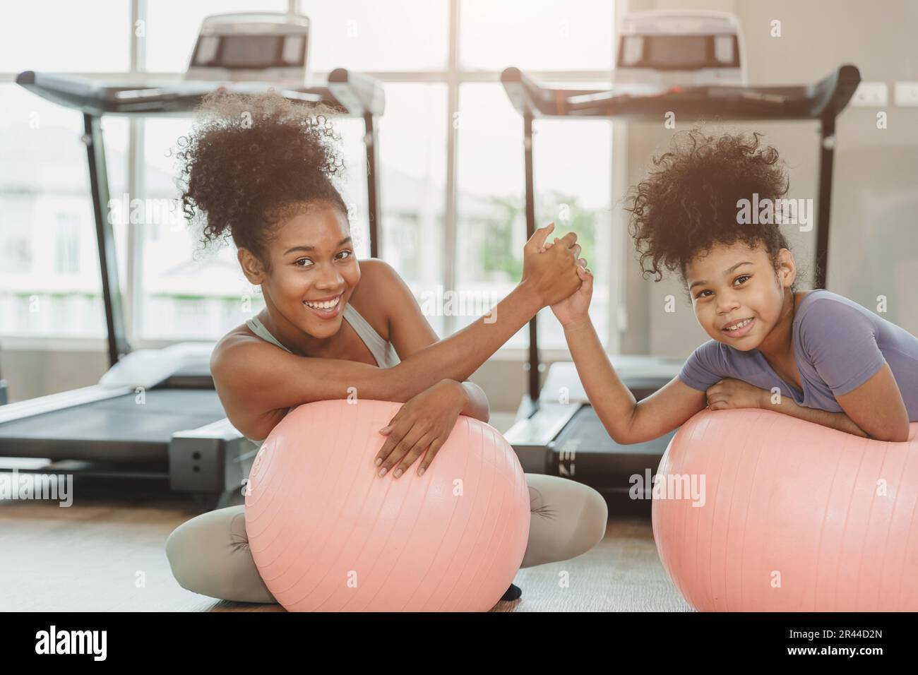 happy sport fitness healthy woman with child smiling in sport club treadmill background Stock Photo