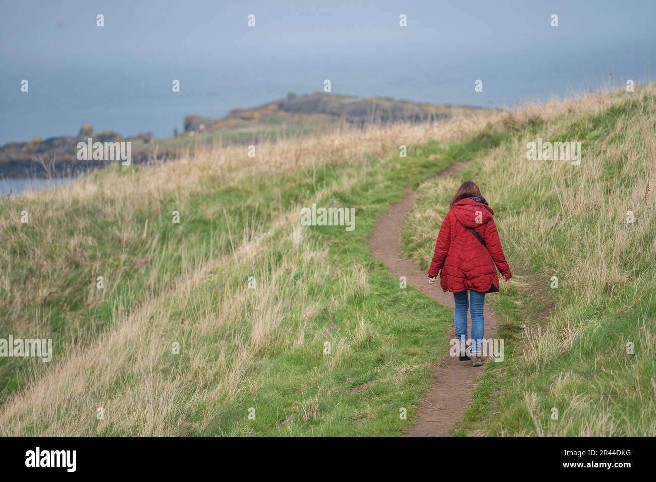 girl walking on a coastal path at north berwick, scotland, uk Stock Photo