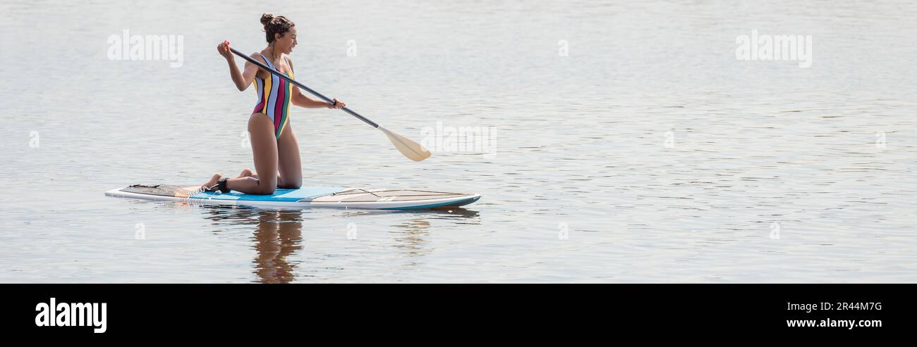 Kneeling woman is paddling with paddle board Vector Image