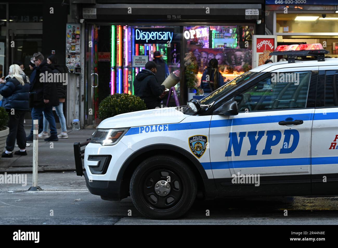 A NYPD patrol vehicle sits outside a "Smoker's World' cannabis
