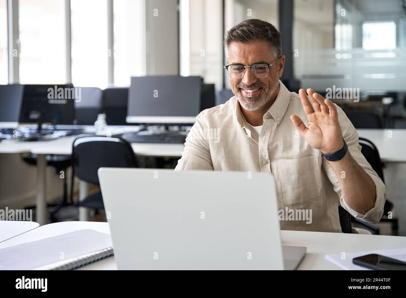 Middle-age Hispanic man using computer remote for business studying, online work Stock Photo
