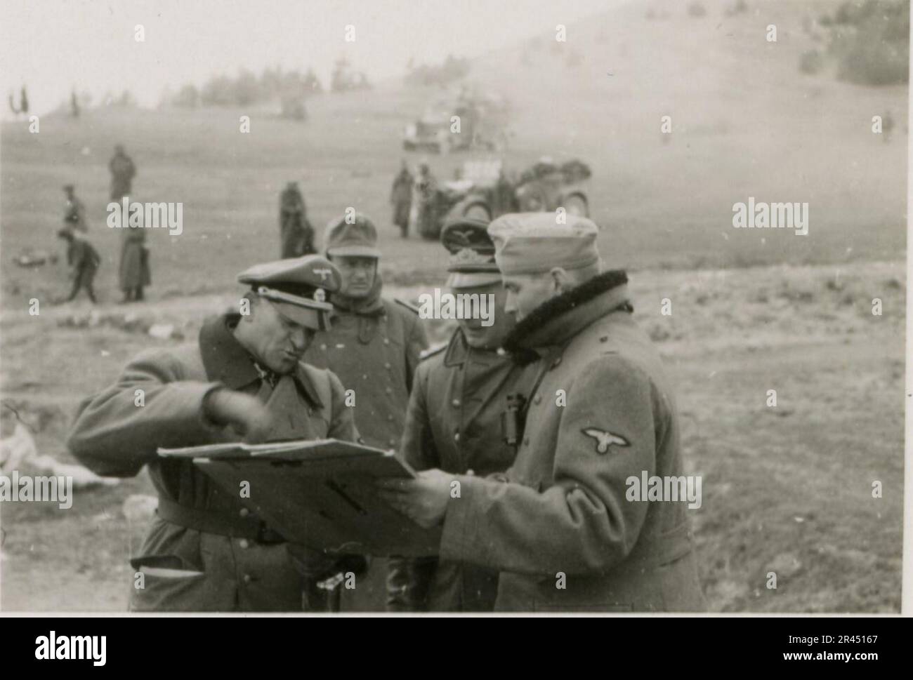 Gunter Alquen (Leibstandarte Adolf Hitler, Greece 1941), an SS photographer, documented Nazi atrocities in Greece during World War II. His lens captured the horror and suffering inflicted upon innocent civilians and resistance fighters.  Images of Sepp Dietrich, accompanied by officers, captured in photographs alongside soldiers, Greek soldiers and civilians, Greek countryside, buildings, pontoon bridge operations. Numerous vehicles bearing tactical symbols, along with the aftermath of destruction: ruined buildings, vehicles, equipment. Artillery shelling and scenes depicting a war-torn countr Stock Photo