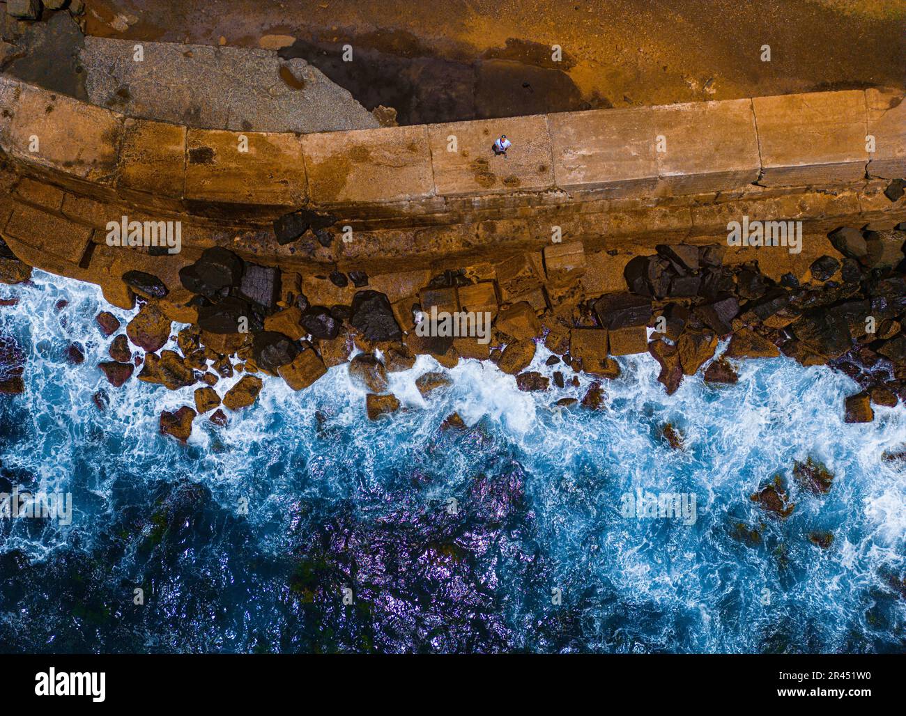 An aerial view of crystal blue water surrounding a rocky beach in ...
