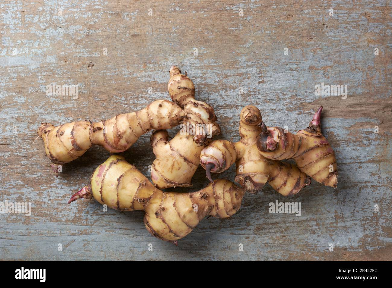 pile of indian shot or canna plant rhizomes or tubers, canna indica, medicinal valued yam native to tropical and subtropical regions isolated on woode Stock Photo