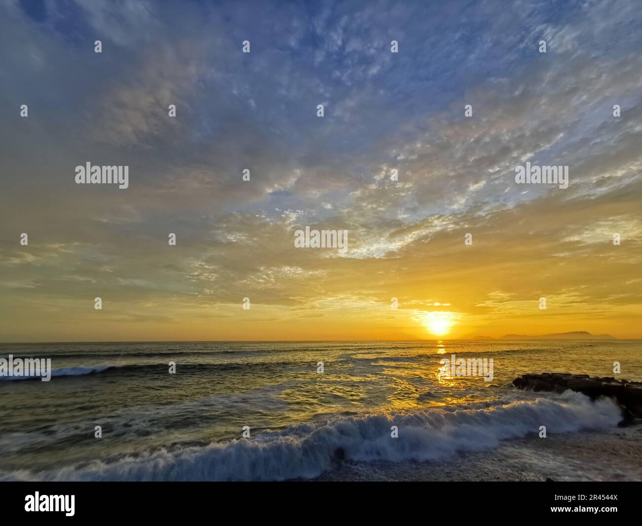 A beautiful sunrise illuminating ocean waves Stock Photo - Alamy