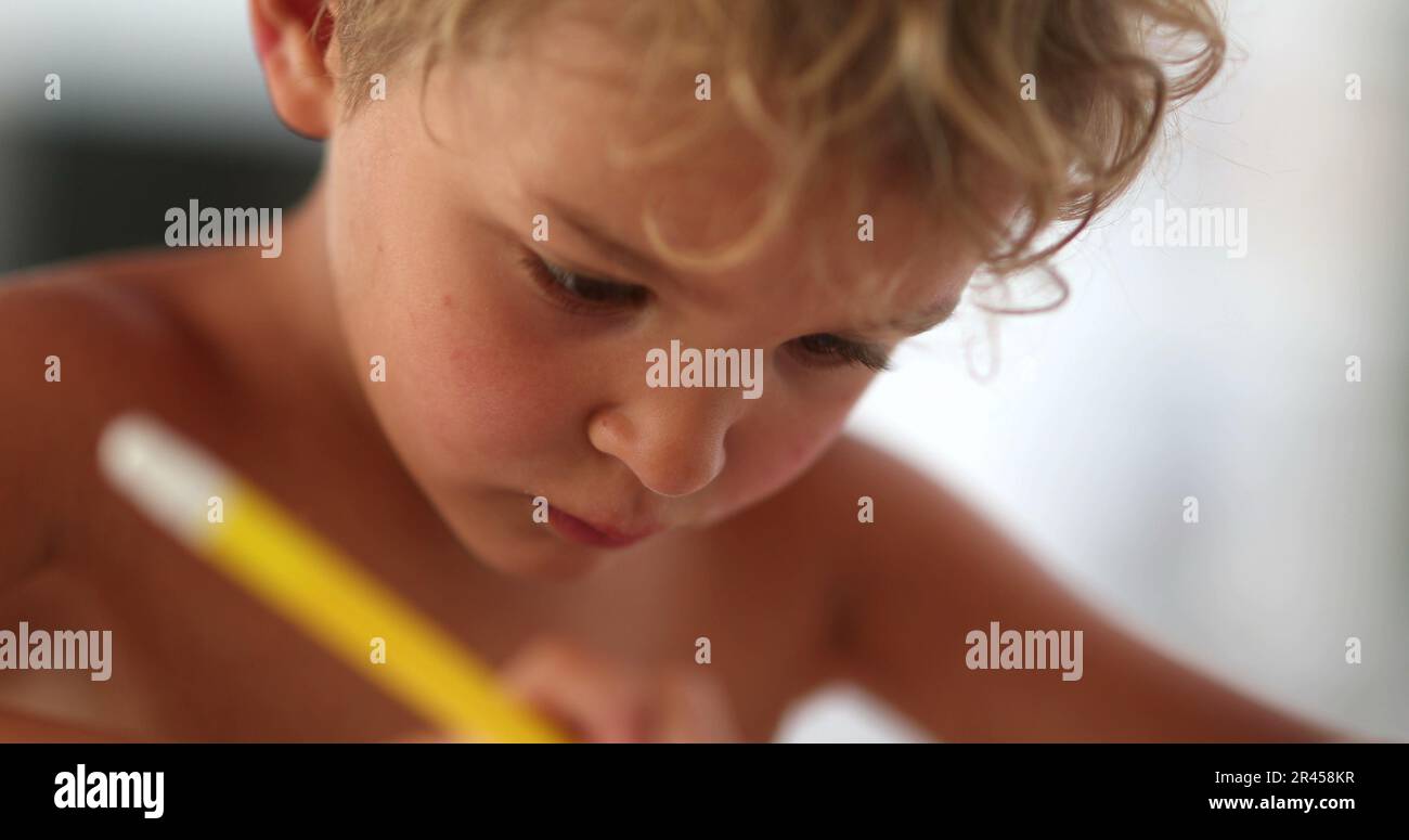 Kid Using Ink Child hand drawing on paper. Concentrated artistic kid skething with ...