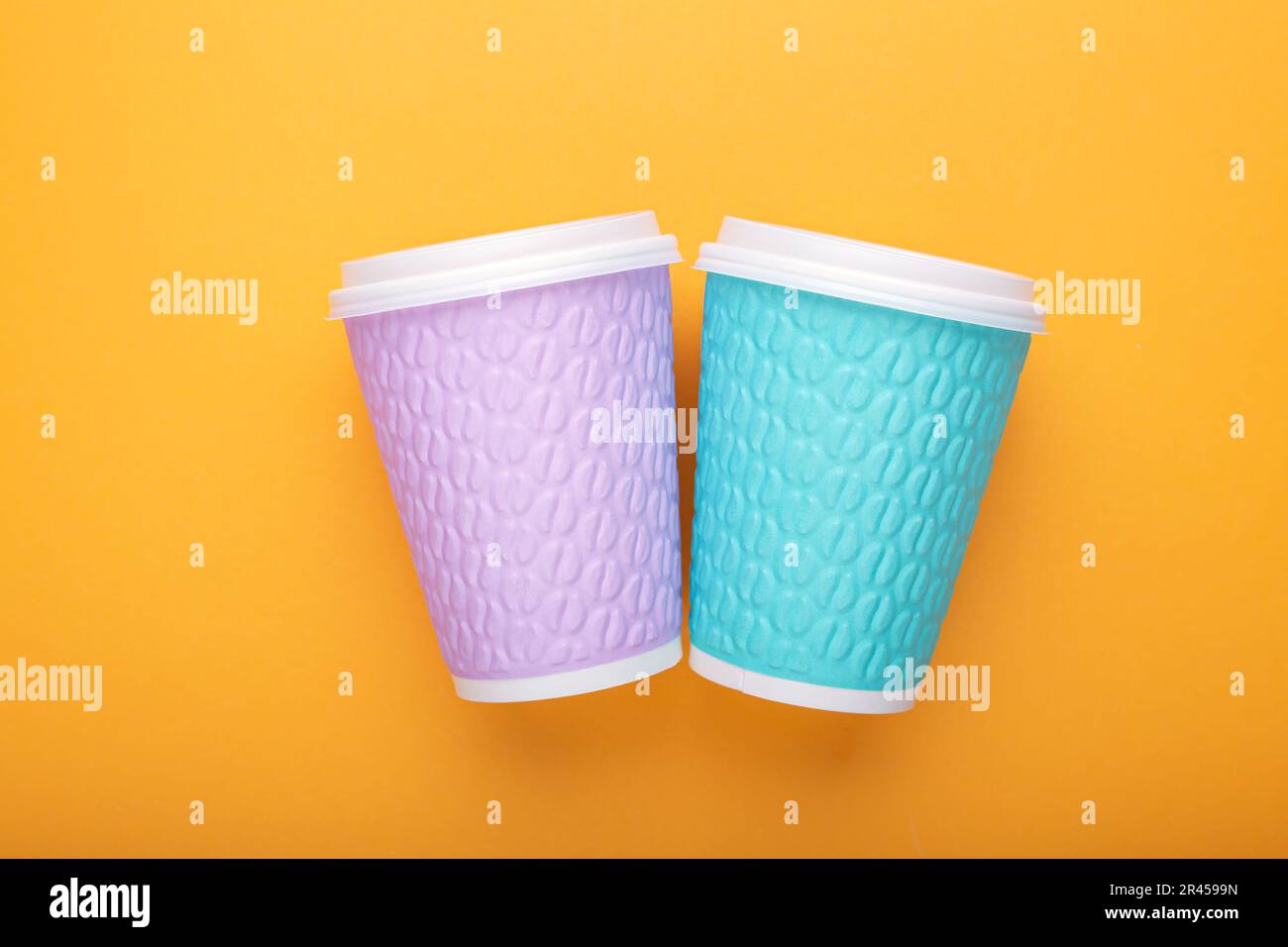 Takeaway coffee cups on yellow background. Two coffee to go cups
