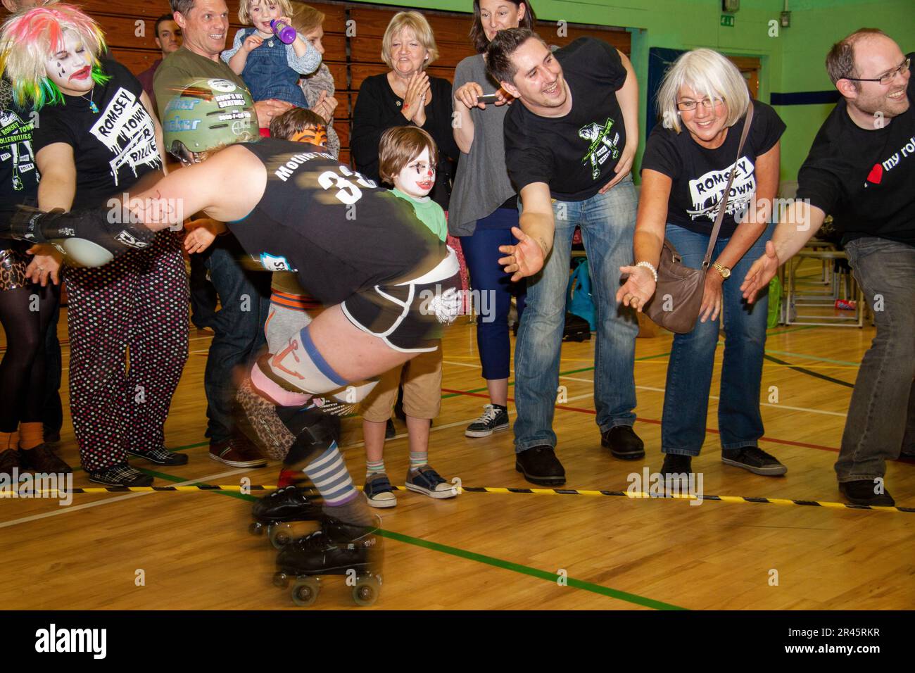 After a roller derby bout the spectators congratulate the skaters with high (perhaps middle) fives. Stock Photo