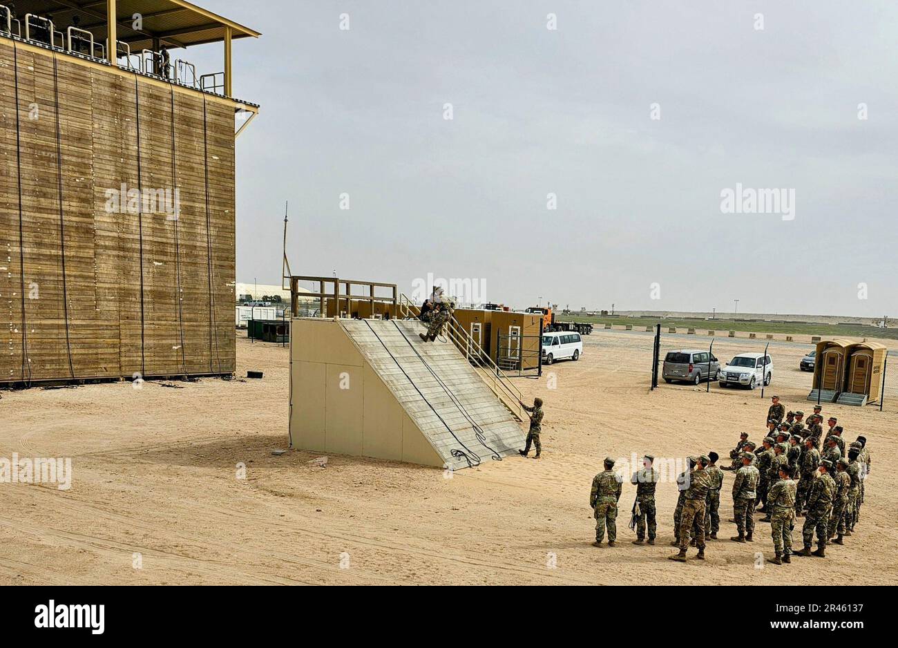 Soldiers look on as fellow Rappel Master Course students rappel down a ...