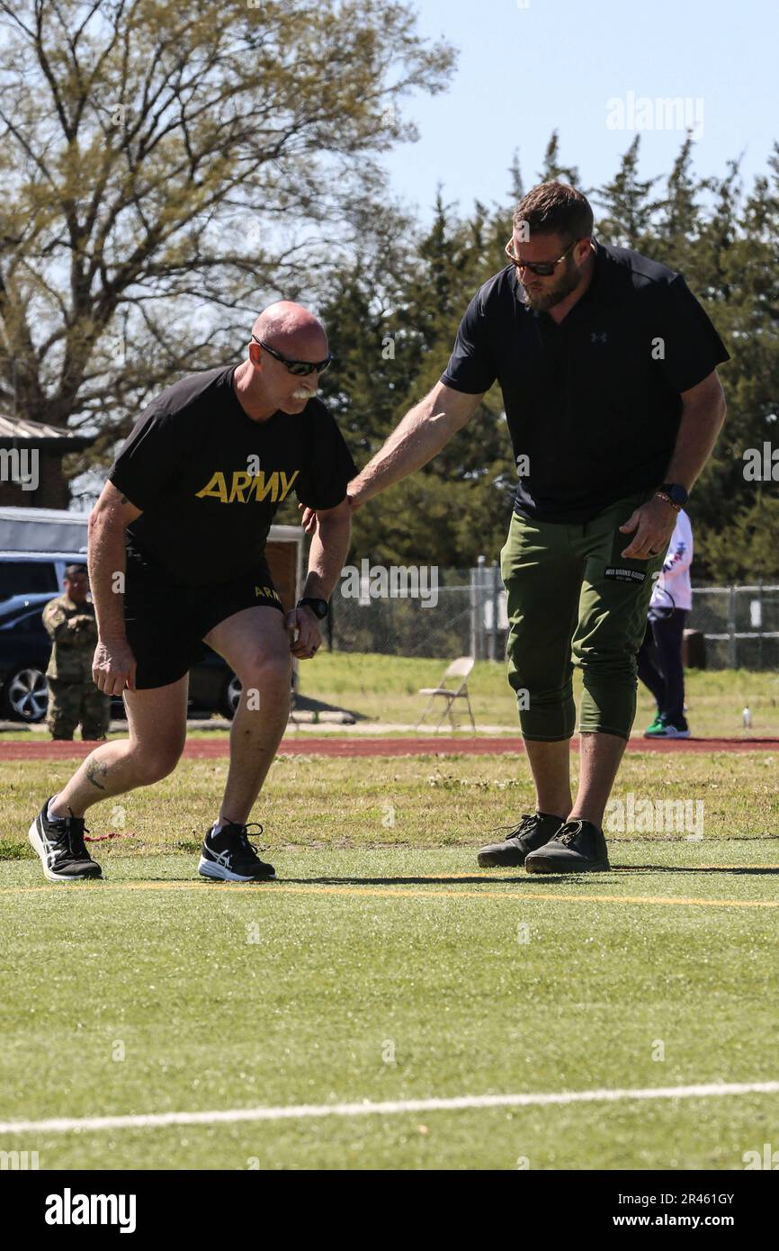 U.S. Army Staff Sgt. Robert Ellison and Coach Tyler Spencer, practice running form during the U.S. Army Adaptive Sports Camp at Fort Bragg, North Carolina, March 30, 2023. Over 70 wounded, ill and injured Soldiers are training in a series of athletic events including archery, cycling, shooting, sitting volleyball, swimming, powerlifting, track, field, rowing, and wheelchair basketball. The Adaptive Sports Camp celebrates wounded, ill, and injured Soldiers ability to recover and overcome. The Army Holds qualifying trials for Active Duty, wounded, ill, or injured Soldiers to assess and select at Stock Photo