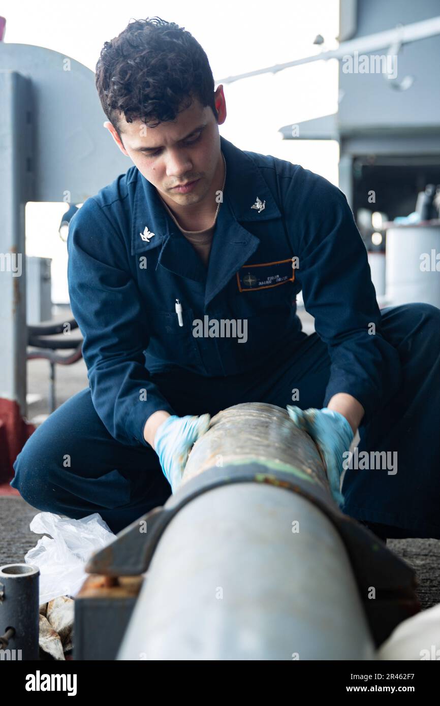 BoatswainÕs Mate Seaman Zach Thornton, from Lexington, Texas, conducts preservation on the fantail of the first-in-class aircraft carrier USS Gerald R. Ford (CVN 78), March 27, 2023. Ford is underway in the Atlantic Ocean executing its Composite Training Unit Exercise (COMPTUEX), an intense, multi-week exercise designed to fully integrate a carrier strike group as a cohesive, multi-mission fighting force and to test their ability to carry out sustained combat operations from the sea. As the first-in-class ship of Ford-class aircraft carriers, CVN 78 represents a generational leap in the U.S. N Stock Photo