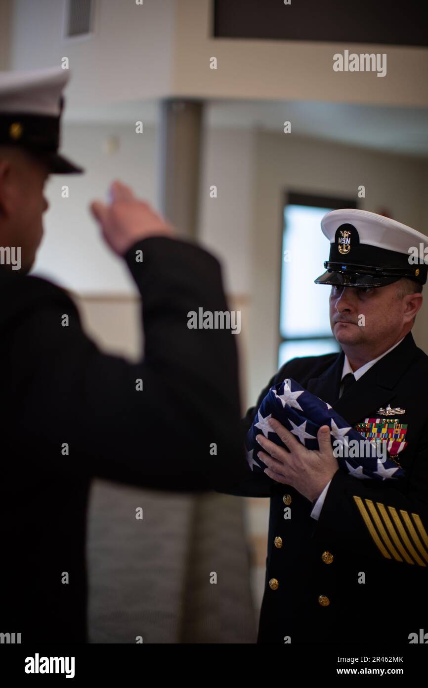 230331-N-XP477-1262 SAN DIEGO (March 31, 2023) – Master Chief Operations Specialist Kermit L. Pollard receives the national ensign as part of a ceremonial passing of the American flag, or Old Glory, during his retirement ceremony at the Murphy Canyon Chapel, March 31, 2023. Pollard is retiring after 27 years of dedicated service to the U.S. Navy. Stock Photo