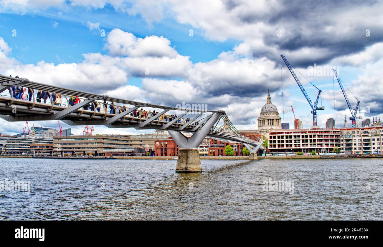 London the Millennium Footbridge over the river Thames leading towards St Pauls Cathedral with large number of tourists Stock Photo