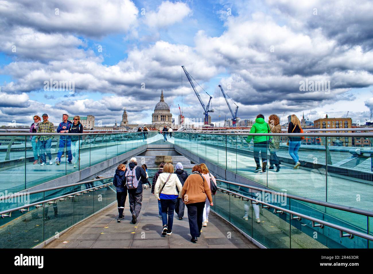 London view from the Millennium Footbridge towards St Pauls Cathedral and walkers on the bridge Stock Photo