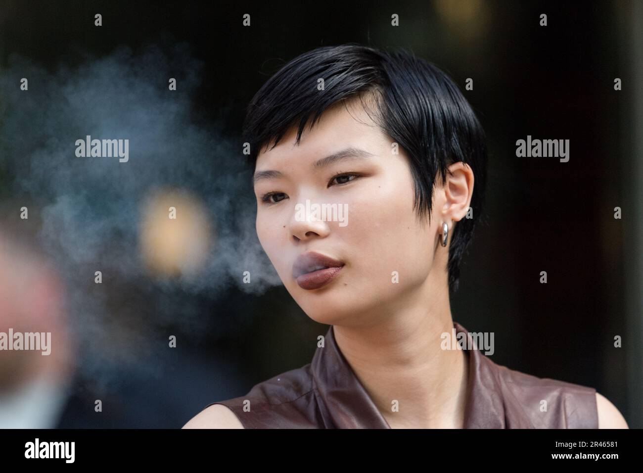 London, UK. 18th May, 2023. Model Kayako Higuchi smokes a cigarette as ...