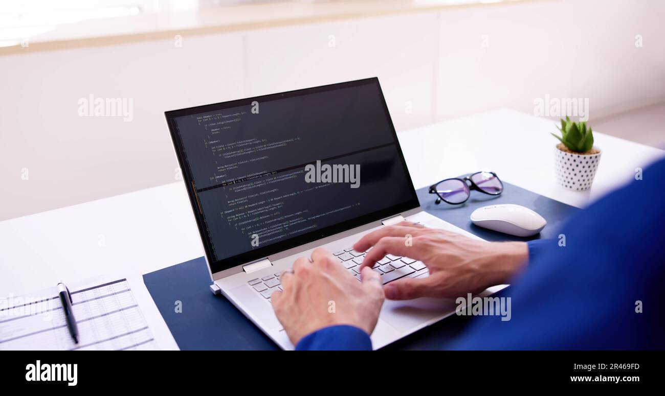 Coder Using Computer At Desk. Web Developer Stock Photo