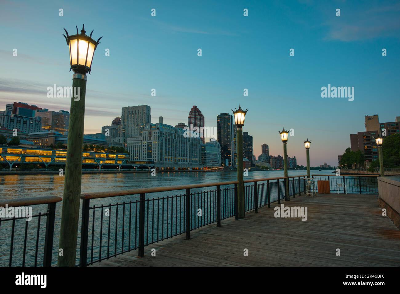 Promenade along the East River with view of Manhattan at blue hour, on Roosevelt Island, New York City Stock Photo