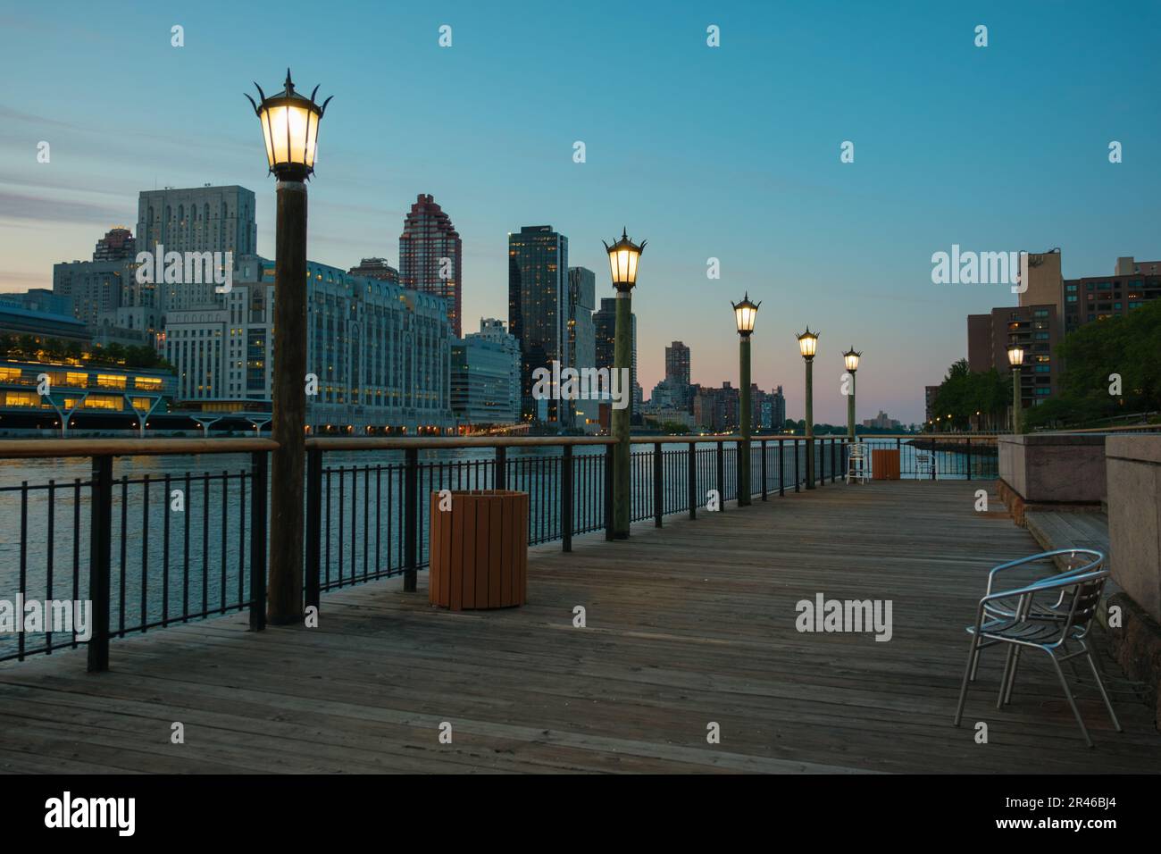 Promenade along the East River with view of Manhattan at blue hour, on Roosevelt Island, New York City Stock Photo