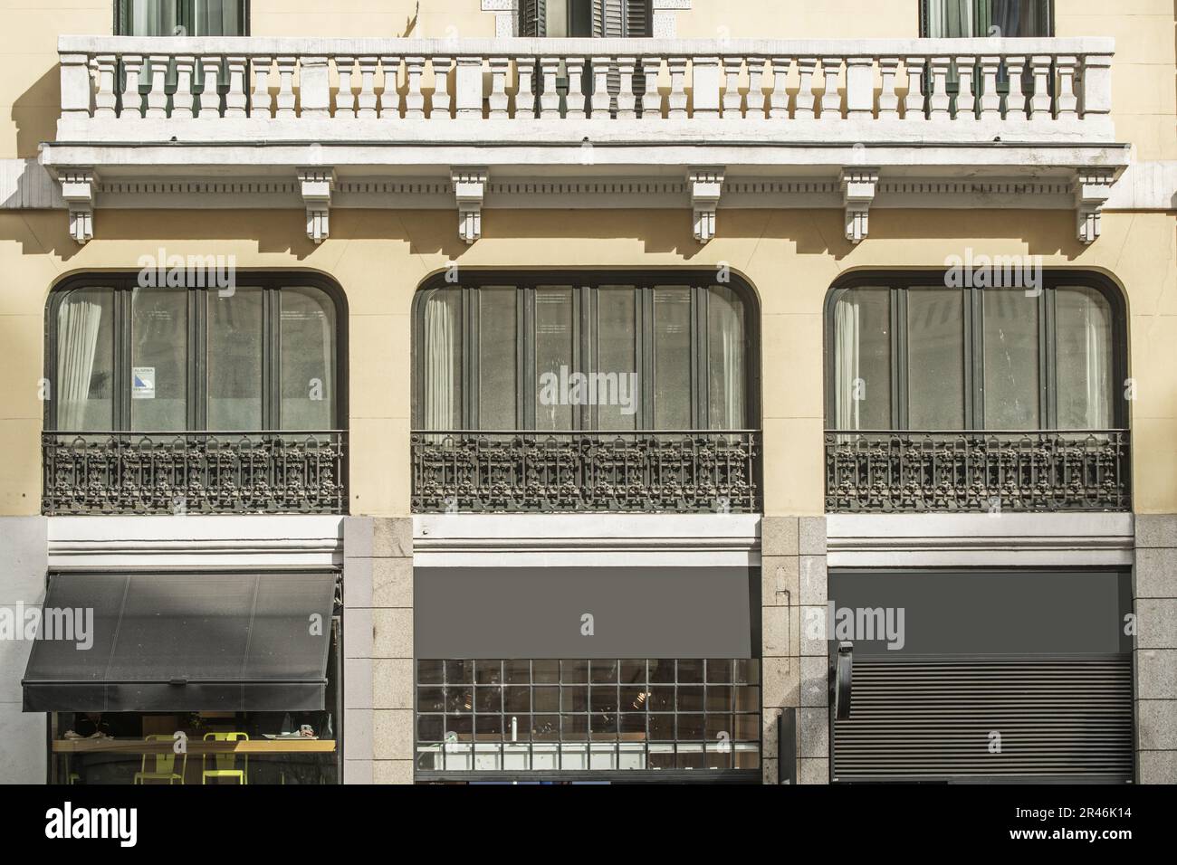 Large windows of a vintage building with artistic metal forging and ...